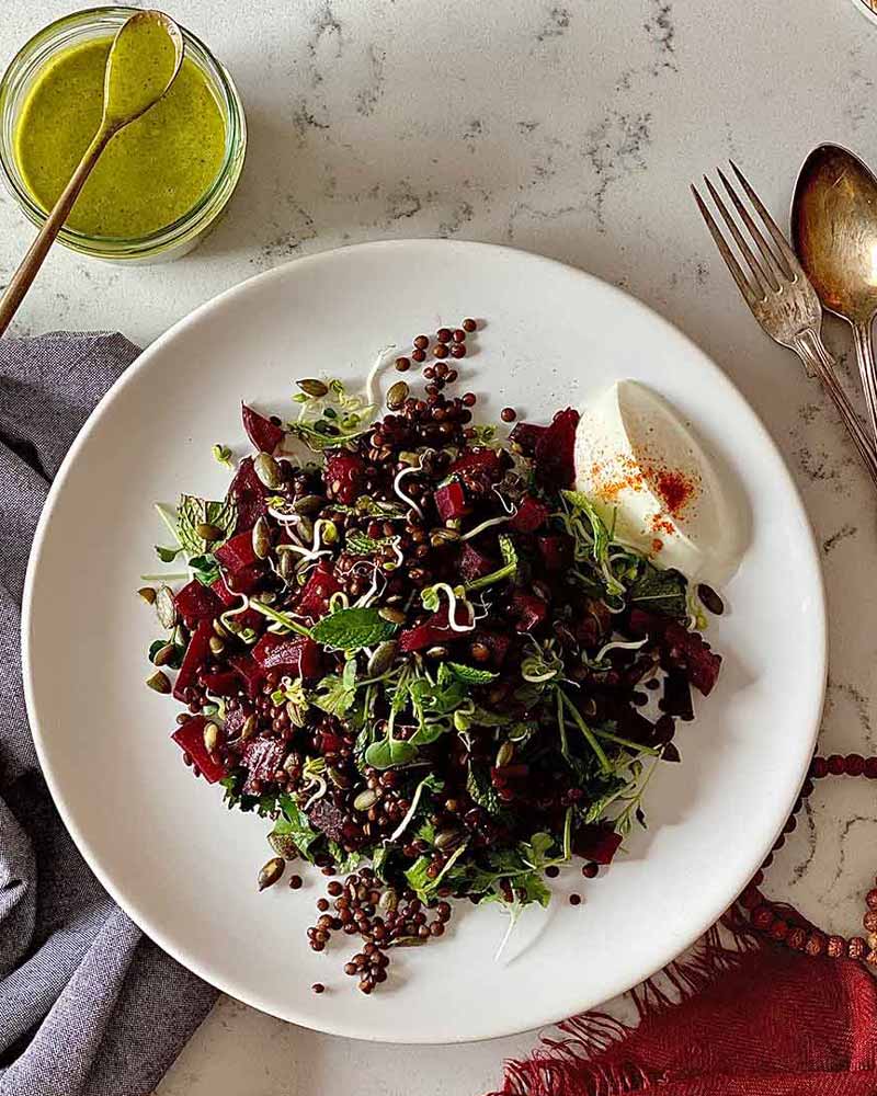 Ensalada tibia de lentejas beluga, remolacha asada y germinados con una vinagreta de cilantro