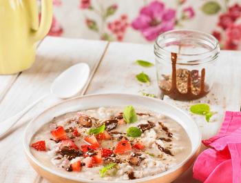 Porridge o crema de coco con chocolate, semillas y fresones